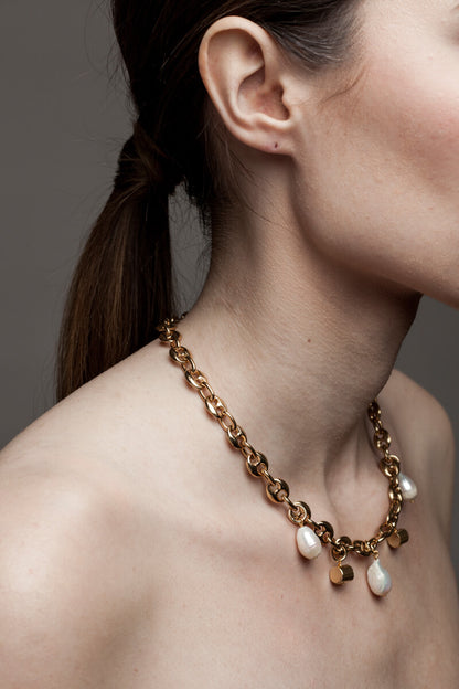 This necklace features 24K gold-plated chain called coffee beans chain and hand cut and 24K gold-plated brass and freshwater pearls.