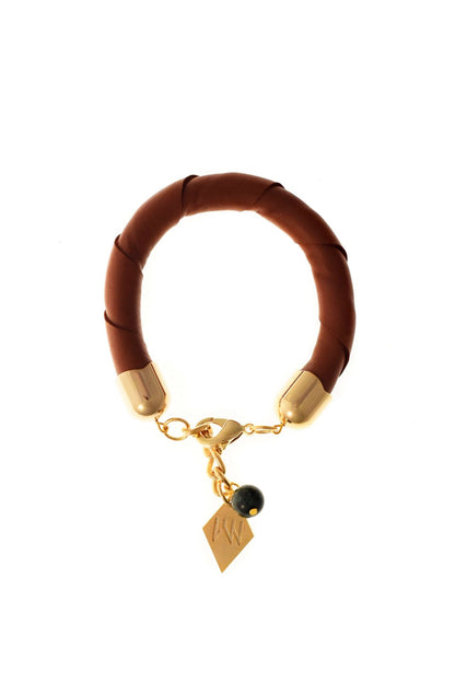 The no. 13 edition of the handcuff bracelet is made of cognac brown leather with galvanized metal components and aventurine.