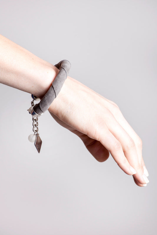 The no. 3 edition of the handcuff bracelet is made of anthracite gray suede with galvanized metal components and quartz. Silver edition.
