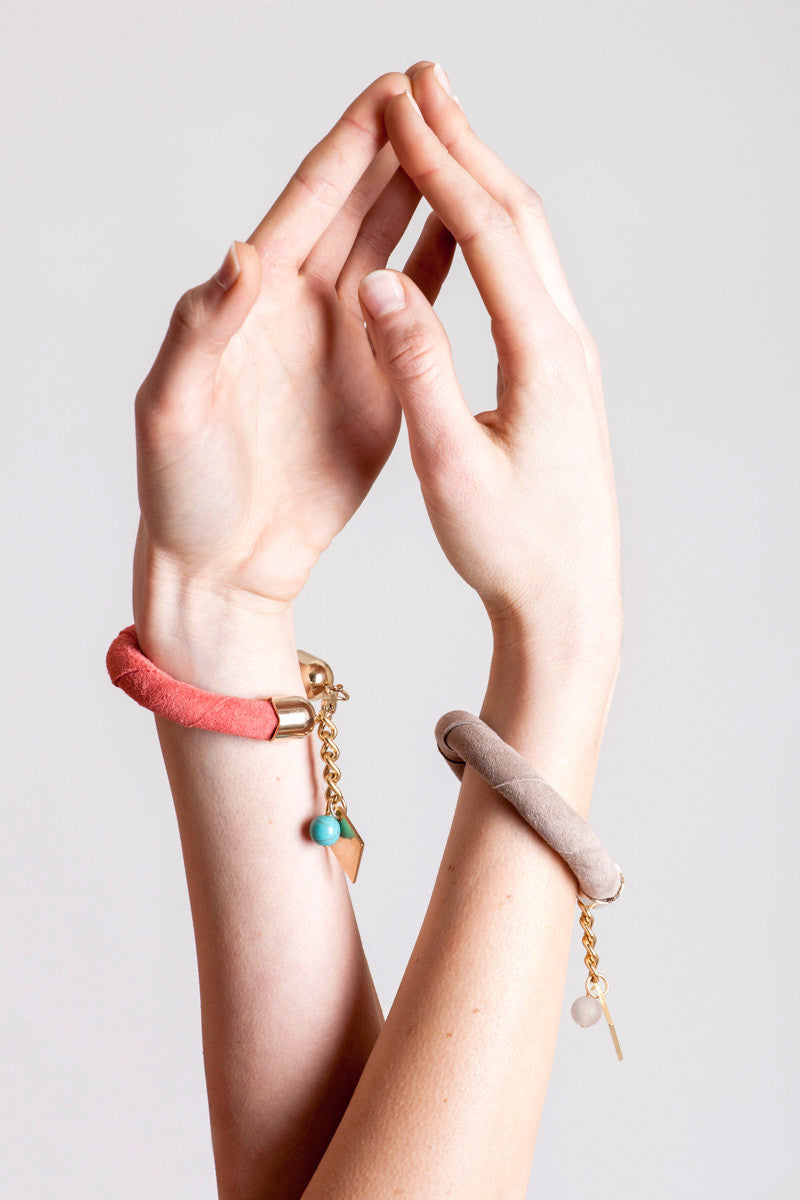 The no. 5 edition of the handcuff bracelet is made of beige suede with galvanized metal components without leather tassel. Gold edition.