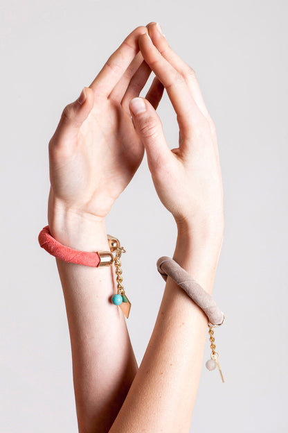 The no. 5 edition of the handcuff bracelet is made of beige suede with galvanized metal components without leather tassel. Gold edition.