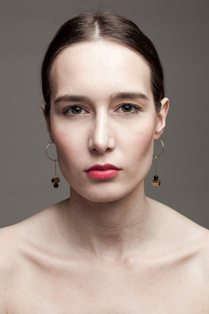 This pair of earring is made of a hoop earring which features 24K gold-plated brass and detachable pendant made of 24K gold-plated brass and onyx.